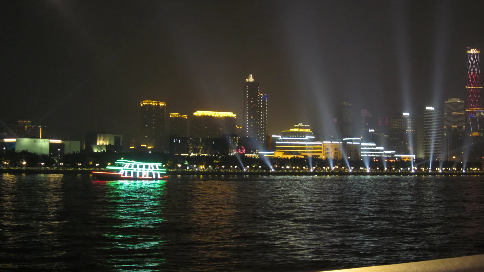 An illuminated cruise boat and Guangzhou skyline on the Pearl River at night