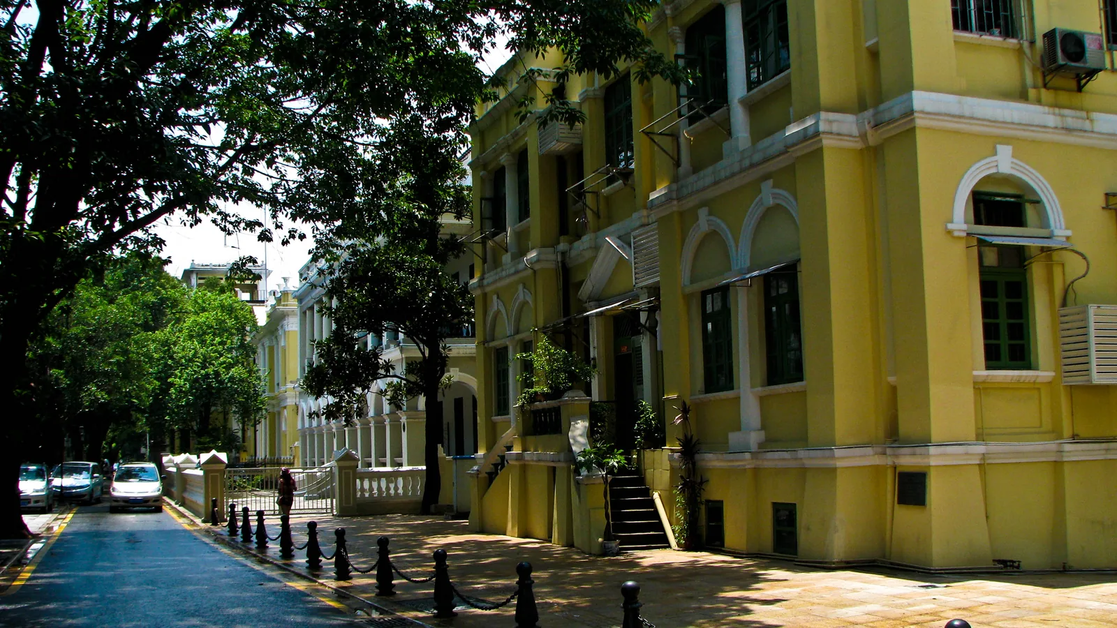 Tree-shaded historic buildings along a quiet street on Shamian Island, Guangzhou