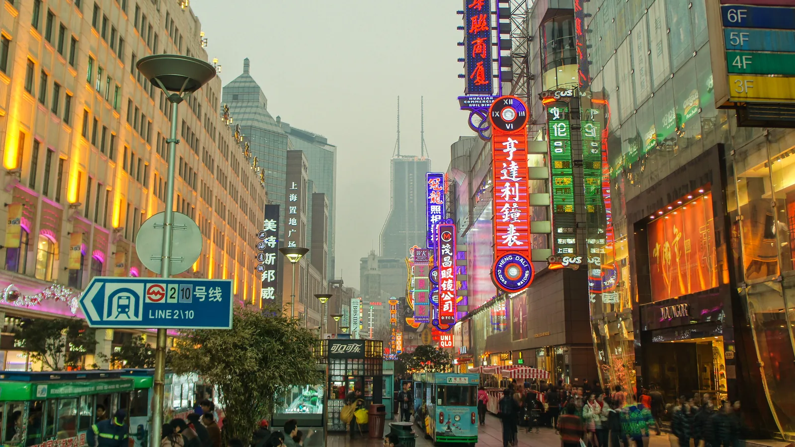 Illuminated storefronts and pedestrians on Nanjing Road