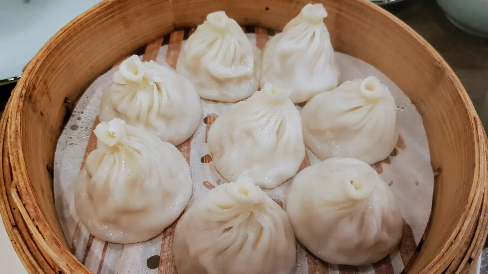 Steamed xiaolongbao soup dumplings in a bamboo basket
